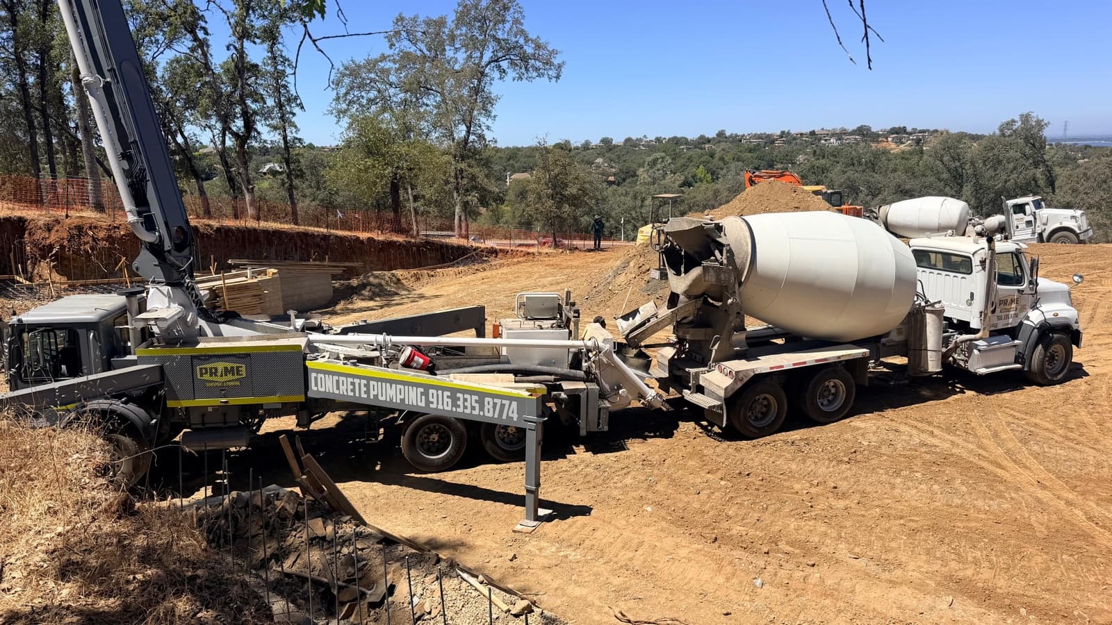 A Prime mixer discharging into a concrete pump on a hillside pour