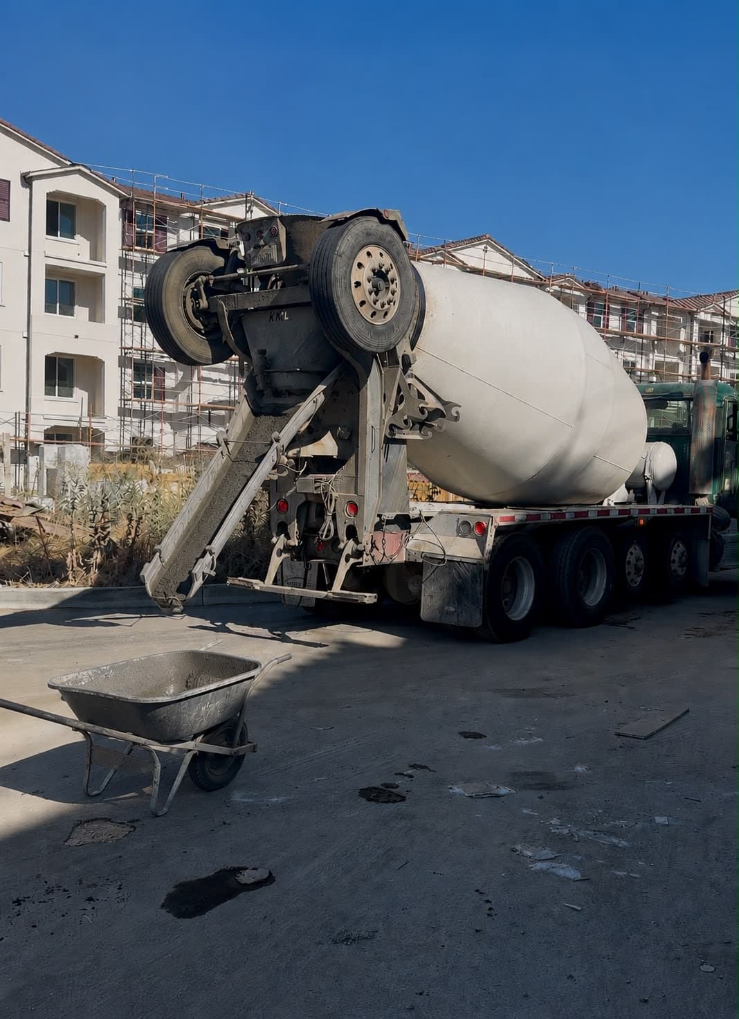 Mixer truck chute discharging into a wheelbarrow on a Sacramento job site
